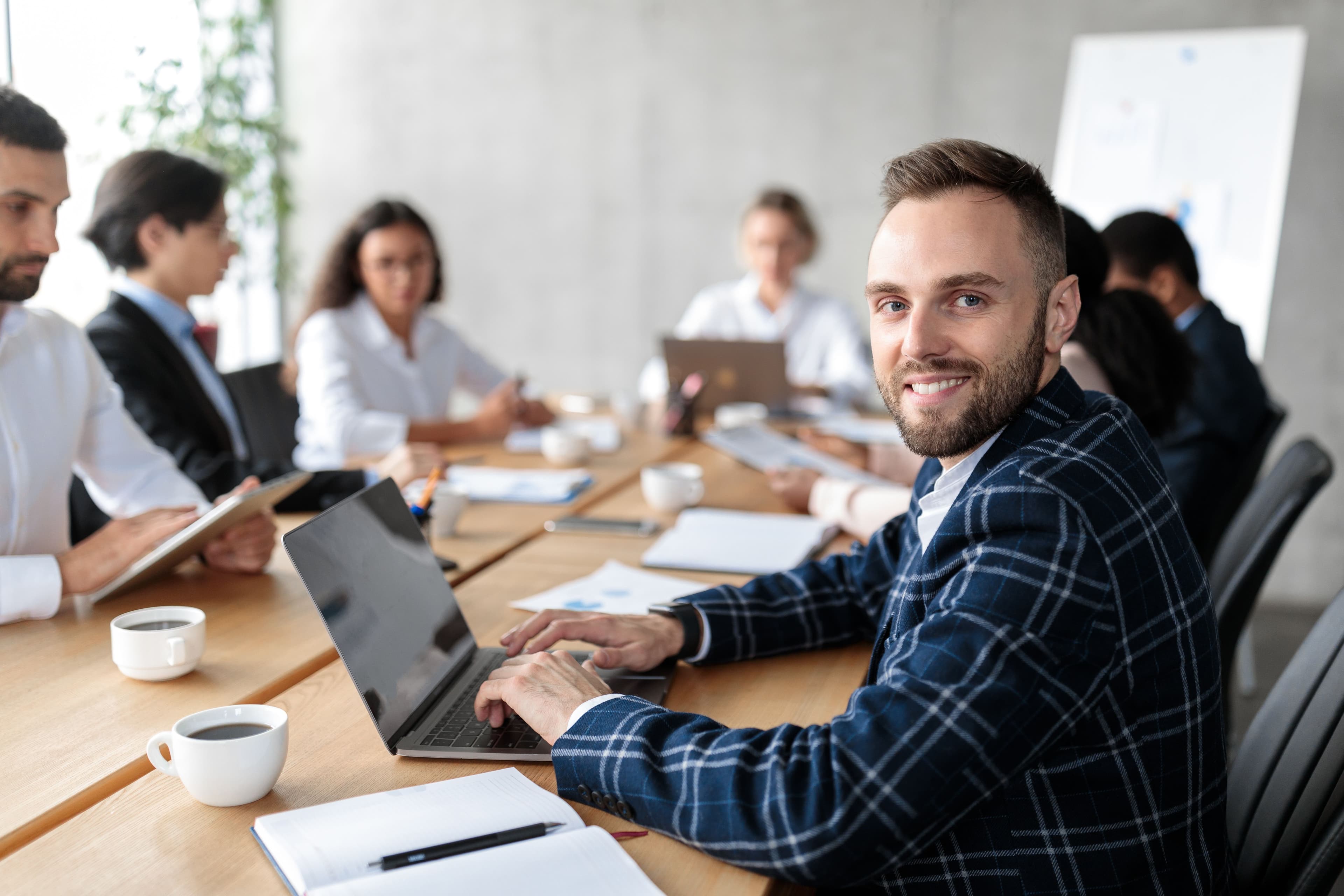 happy-businessman-with-laptop-at-corporate-meeting-2025-03-18-18-24-29-utc.jpg